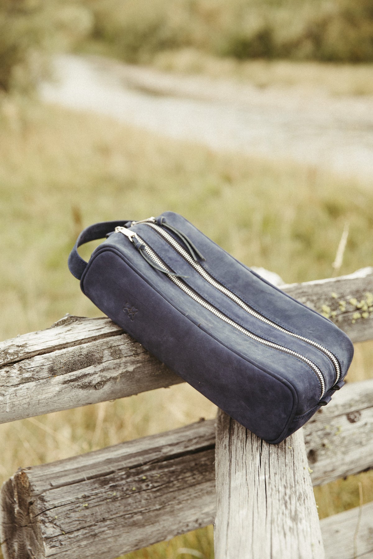Azul Vino Travel Carrier sitting on a fence in a field